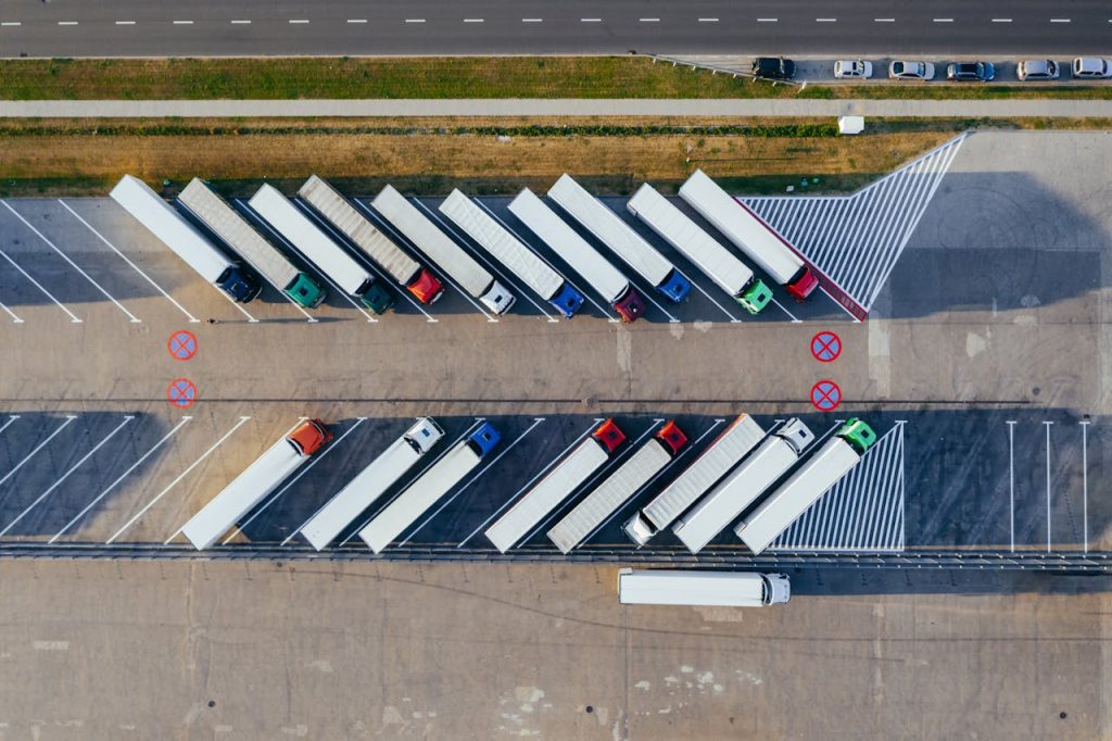 aerial-photography-of-trucks-parked-2800121 Overhead shot of semi-trucks parked in Poznań, Poland, demonstrating transportation logistics.