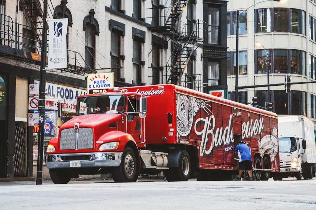 red-budweiser-trailer-truck-2676842 Budweiser truck unloading on a busy Chicago street, highlighting urban transportation and commerce.